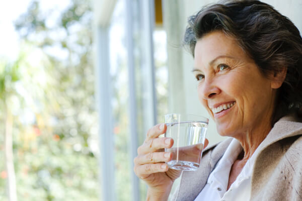 Illustratie van een klok die de verschillende momenten van de dag aangeeft waarop we water drinken