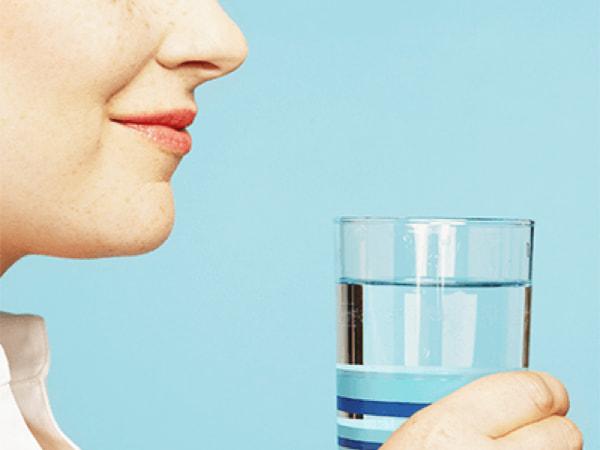 Femme tenant un verre d'eau minérale Hépar